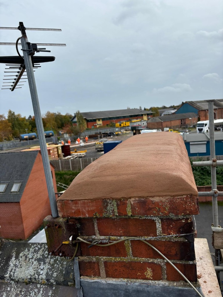Restored brick chimney stack with smooth new mortar capping, flaunching and lead flashing repair in Shropshire